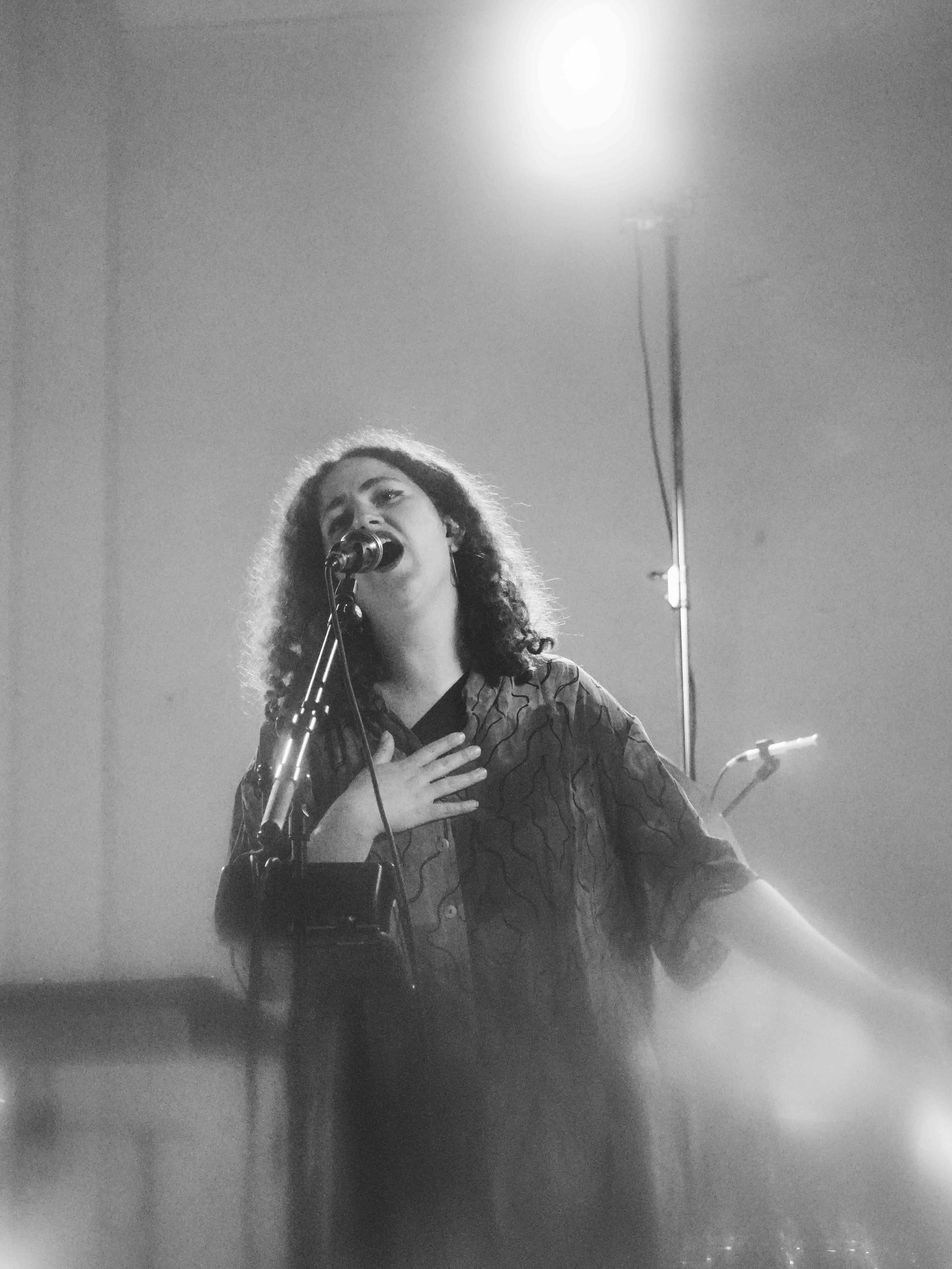 Maria Wadi singt auf einer Bühne in ein Mikrofon